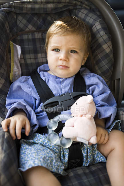 Portrait of thoughtful baby boy sitting in baby seat — Stock Photo