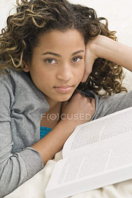 Portrait d'une adolescente reposant avec un livre — Photo de stock