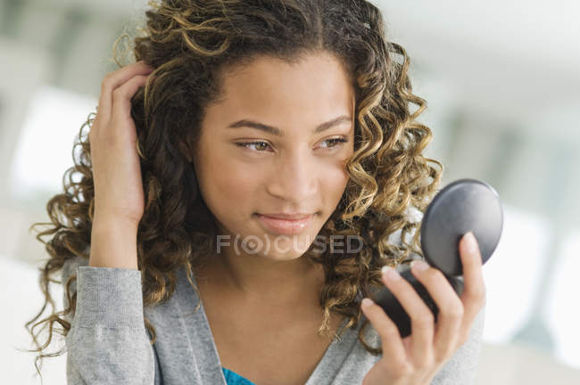 Close-up of smiling teenage girl looking at vanity mirror — Stock Photo