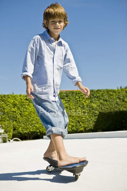 Souriant garçon skateboard en été arrière-cour — Photo de stock