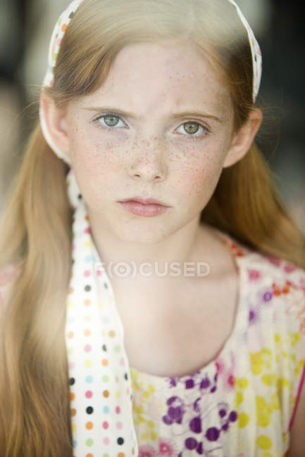 Portrait of sad ginger girl with freckles looking at camera — Stock Photo