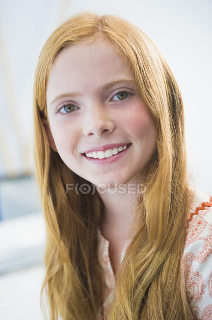 Porträt eines lächelnden Ingwermädchens, das in die Kamera blickt — Stockfoto