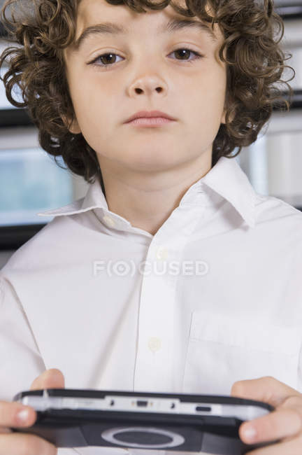 Retrato de niño sosteniendo un videojuego - foto de stock