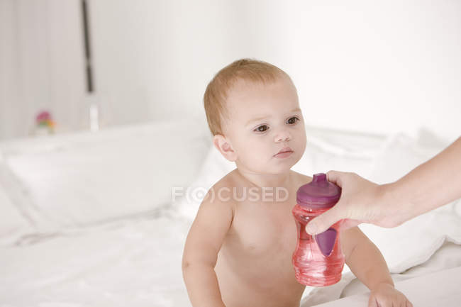 Крупним планом жіноча рука дає дитячу пляшку дочці — стокове фото