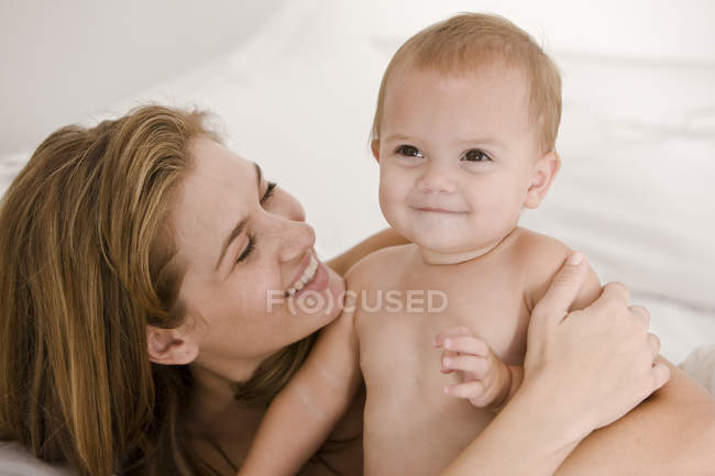 Mujer feliz llevando hija bebé - foto de stock