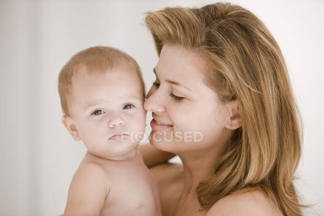 Mujer feliz llevando hija bebé - foto de stock