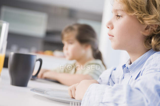 Boy and a girl at a dining table — Stock Photo