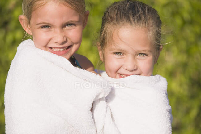 Retrato de duas meninas envolto em uma toalha e sorrindo — Fotografia de Stock