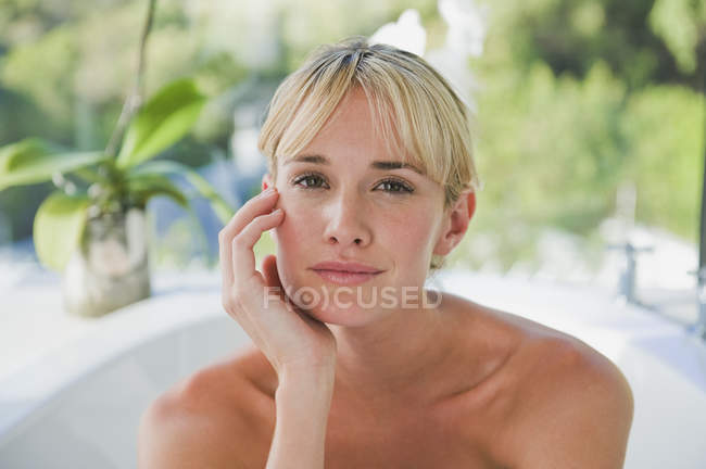 Портрет молодої блондинки у ванній з садом на фоні — стокове фото