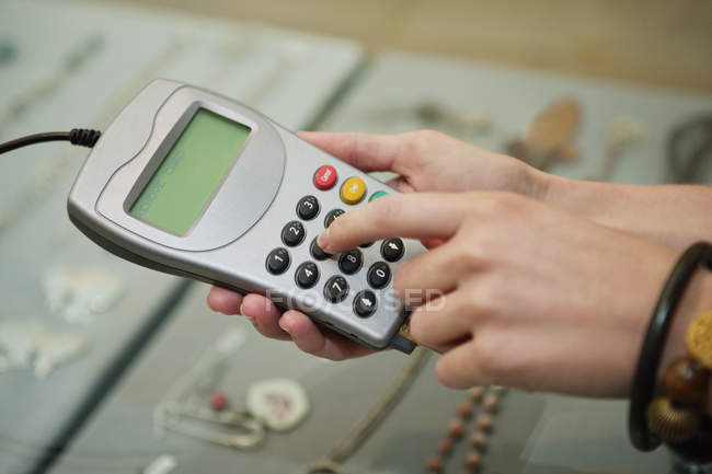 Close-up of customer using credit card reader in boutique — Stock Photo