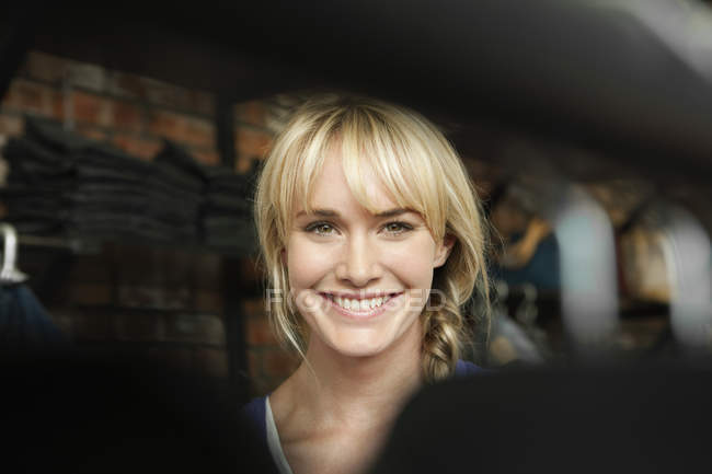 Smiling blond woman in boutique looking at camera — Stock Photo