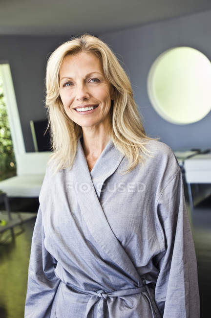 Портрет зрілої жінки в халаті посміхається — стокове фото