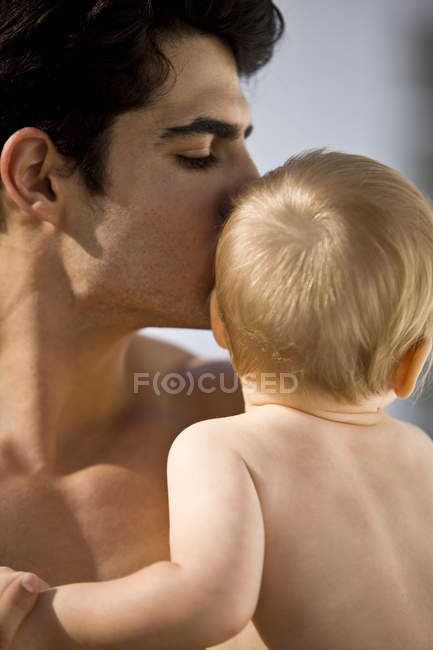 Primer plano del hombre besando al bebé hijo - foto de stock
