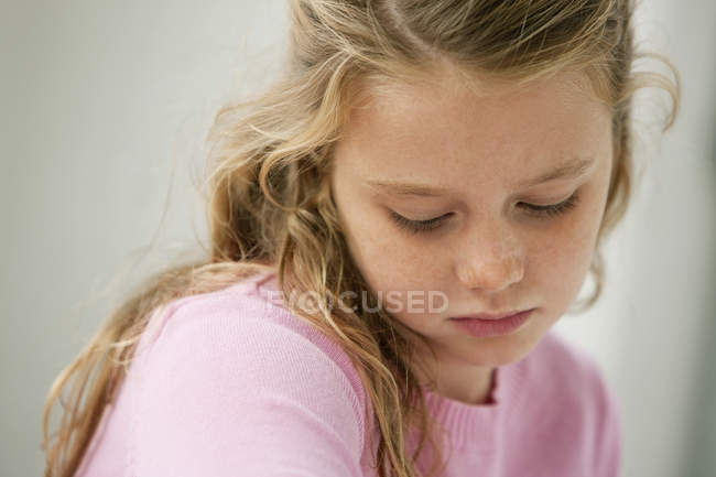 Close-up of thoughtful little girl looking down — Stock Photo