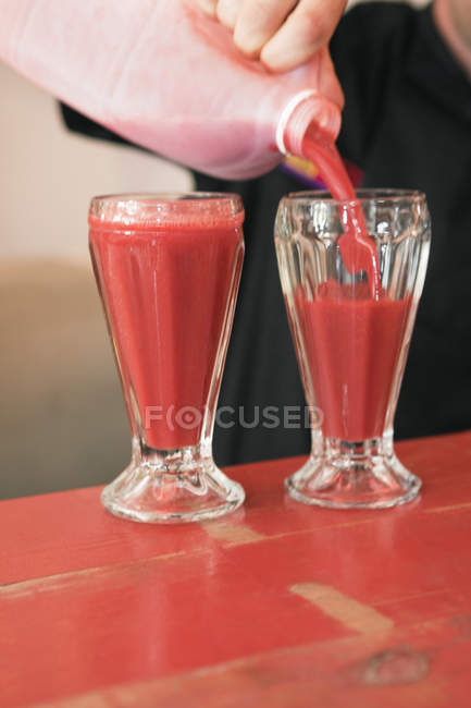 Close-up of person pouring bloody mary into glasses — Stock Photo