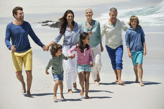 Щаслива сім'я, що йде піщаним пляжем — стокове фото
