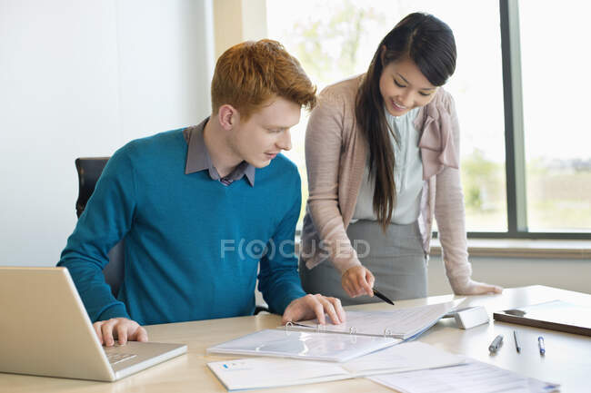 Empresario examinando documentos con su secretario - foto de stock
