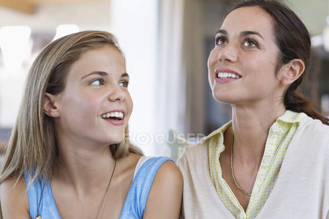 Mulher sorrindo com sua filha em casa — Fotografia de Stock