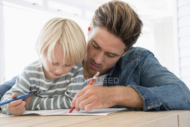 Padre e figlio che fanno i compiti a casa — Foto stock
