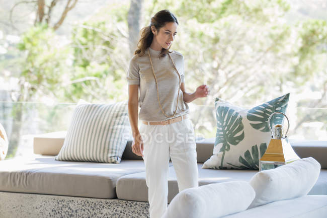 Mujer mirando linterna en sala de estar de la casa moderna - foto de stock