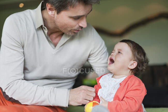 Hombre consolando a su hija llorando - foto de stock