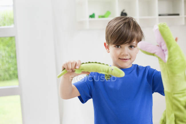 Портрет маленького хлопчика, який грає з тваринними іграшками — стокове фото