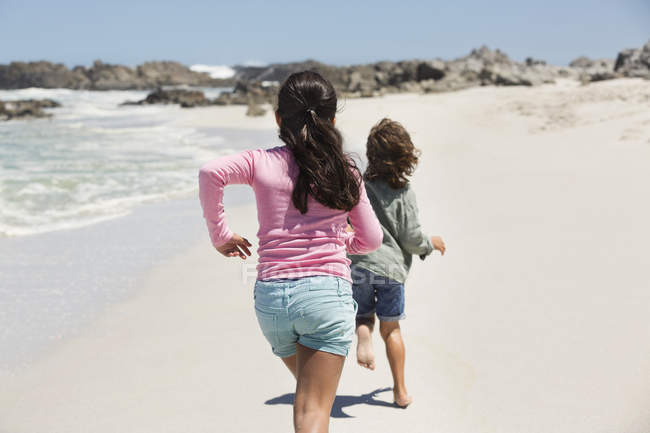Enfants ludiques courir sur la plage de sable fin — Photo de stock