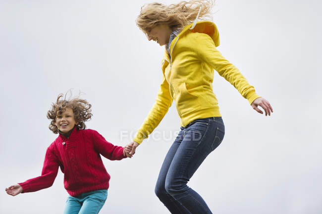 Mujer con su hijo saltando y sonriendo - foto de stock