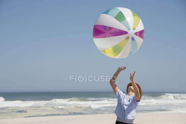 Menina jogando na praia de verão com bola colorida — Fotografia de Stock