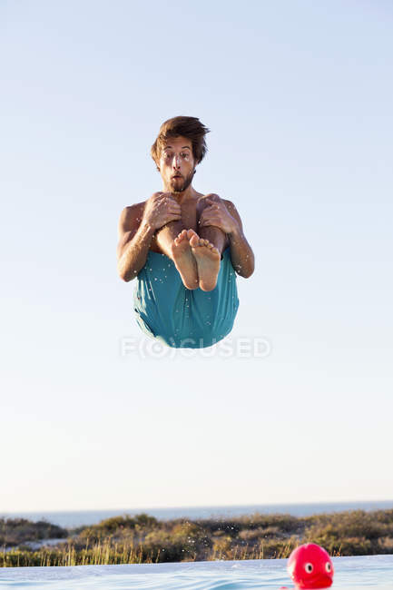 Homem alegre pulando na piscina — Fotografia de Stock