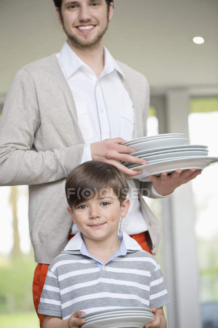 Мужчина и сын готовят тарелки для обеда дома — стоковое фото