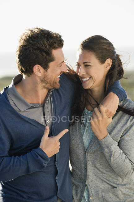 Sonriente pareja enamorada caminando por la costa del mar - foto de stock