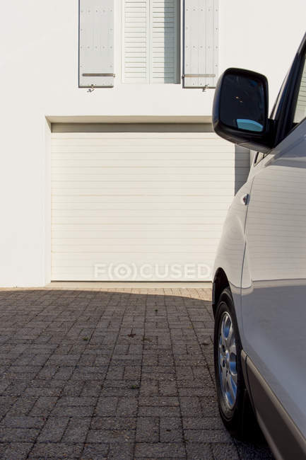 Car parked outside white building on street — Stock Photo