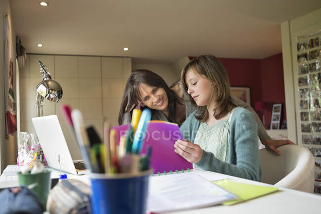 Girl studying with her mother at home — Stock Photo