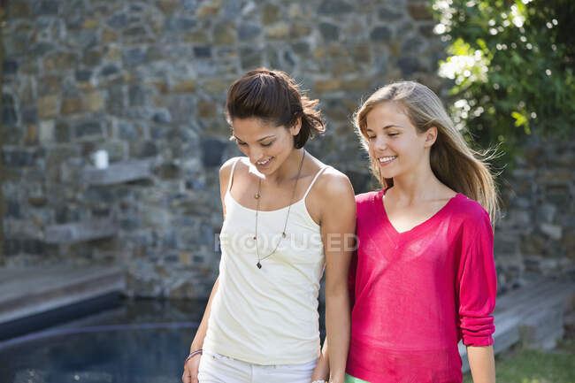 Smiling mother and daughter walking and holding each other's hands — Stock Photo