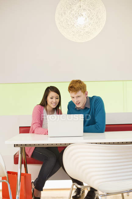 Молода пара працює на ноутбуці в сучасному офісі — стокове фото