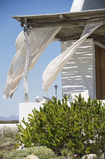 Pórtico da casa moderna com cortinas no vento — Fotografia de Stock