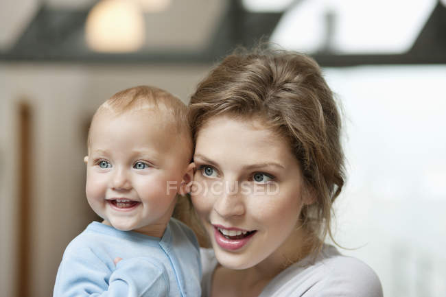 Close-up of woman with baby girl looking away — Stock Photo