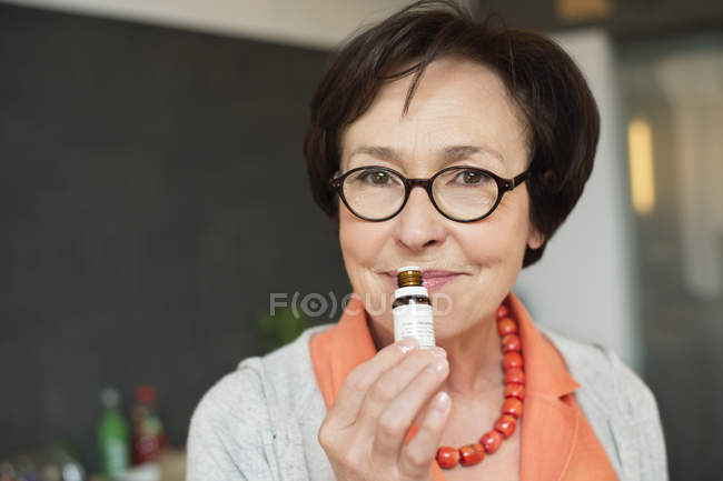 Porträt einer Seniorin, die Aromatherapie-Öl riecht — Stockfoto