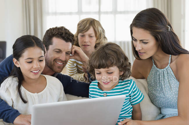 Family looking at a laptop — Stock Photo