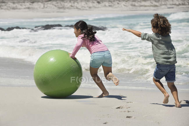 Діти грають на піщаному пляжі з м'ячем — стокове фото