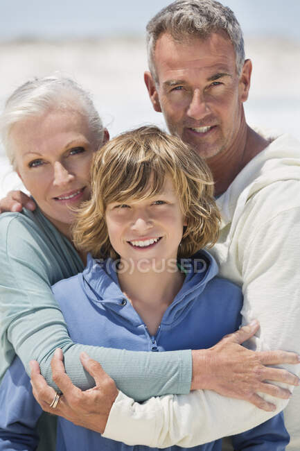 Ritratto di un ragazzo con i nonni sulla spiaggia — Foto stock