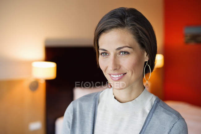 Портрет усміхненої елегантної жінки в готельному номері — стокове фото