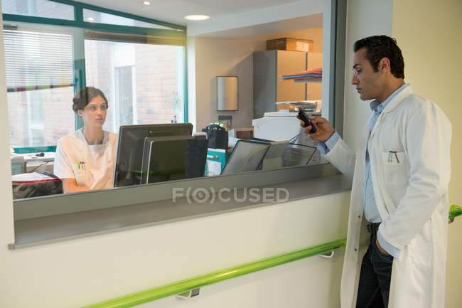 Enfermeira ocupada a falar com o médico no hospital — Fotografia de Stock