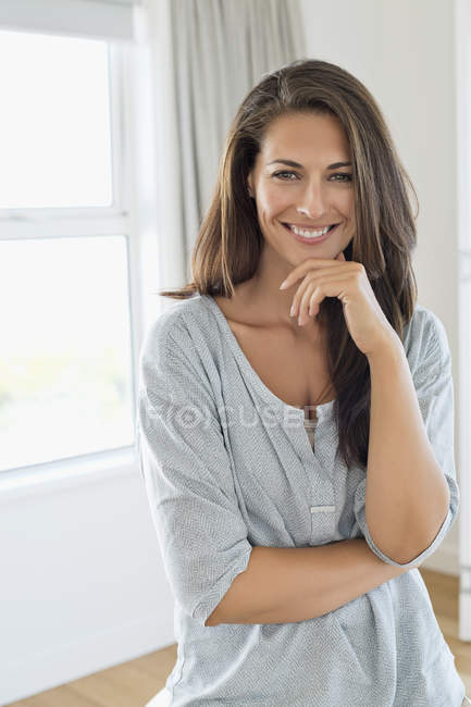 Портрет улыбающейся женщины, улыбающейся с рукой на подбородке — стоковое фото