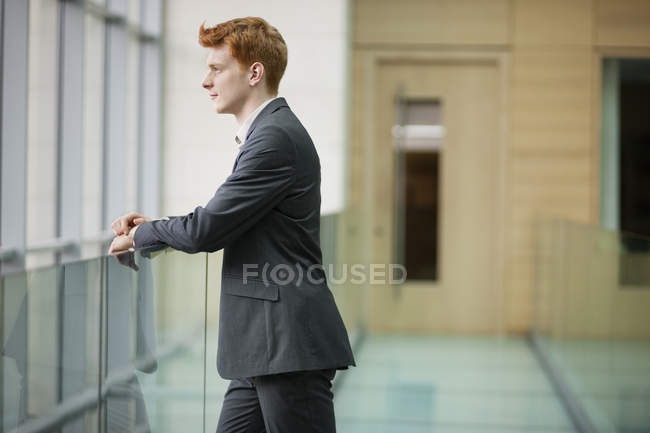 Ritratto di giovane uomo d'affari che fissa nel corridoio — Foto stock