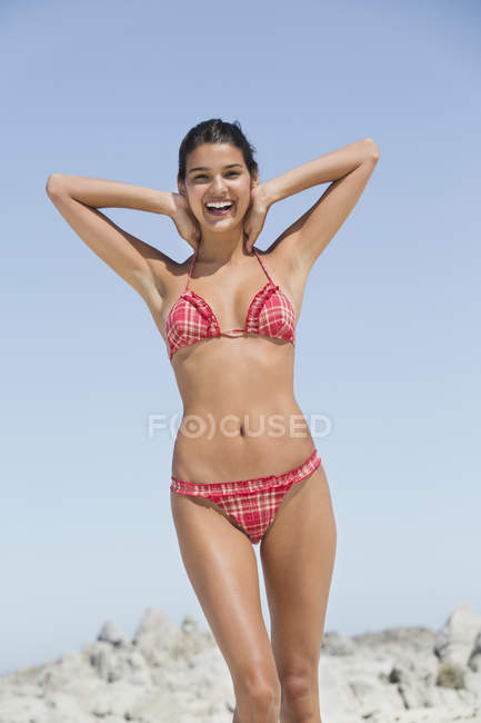 Souriante jeune femme jouissant sur la plage en été — Photo de stock