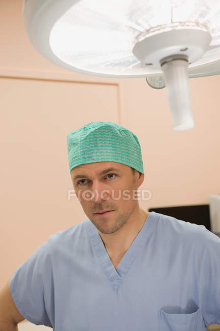 Чоловічий хірург стоїть в операційній кімнаті — стокове фото