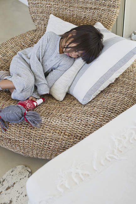 Carino bambina dormire su sedia di vimini — Foto stock