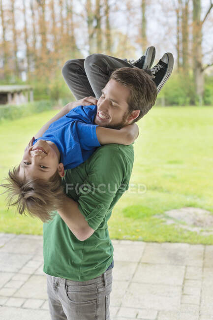 Мужчина играет со своим сыном в парке — стоковое фото
